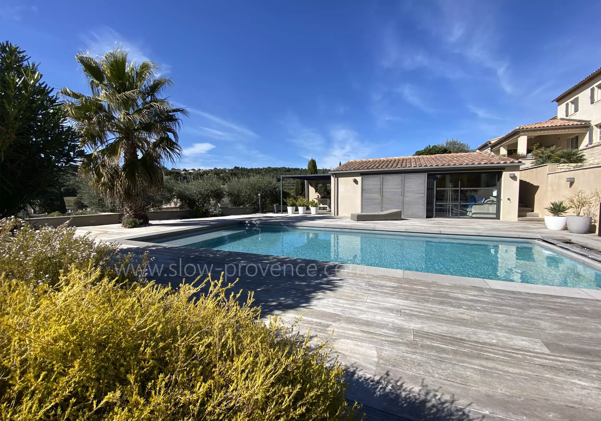 The cottage opening onto the pool