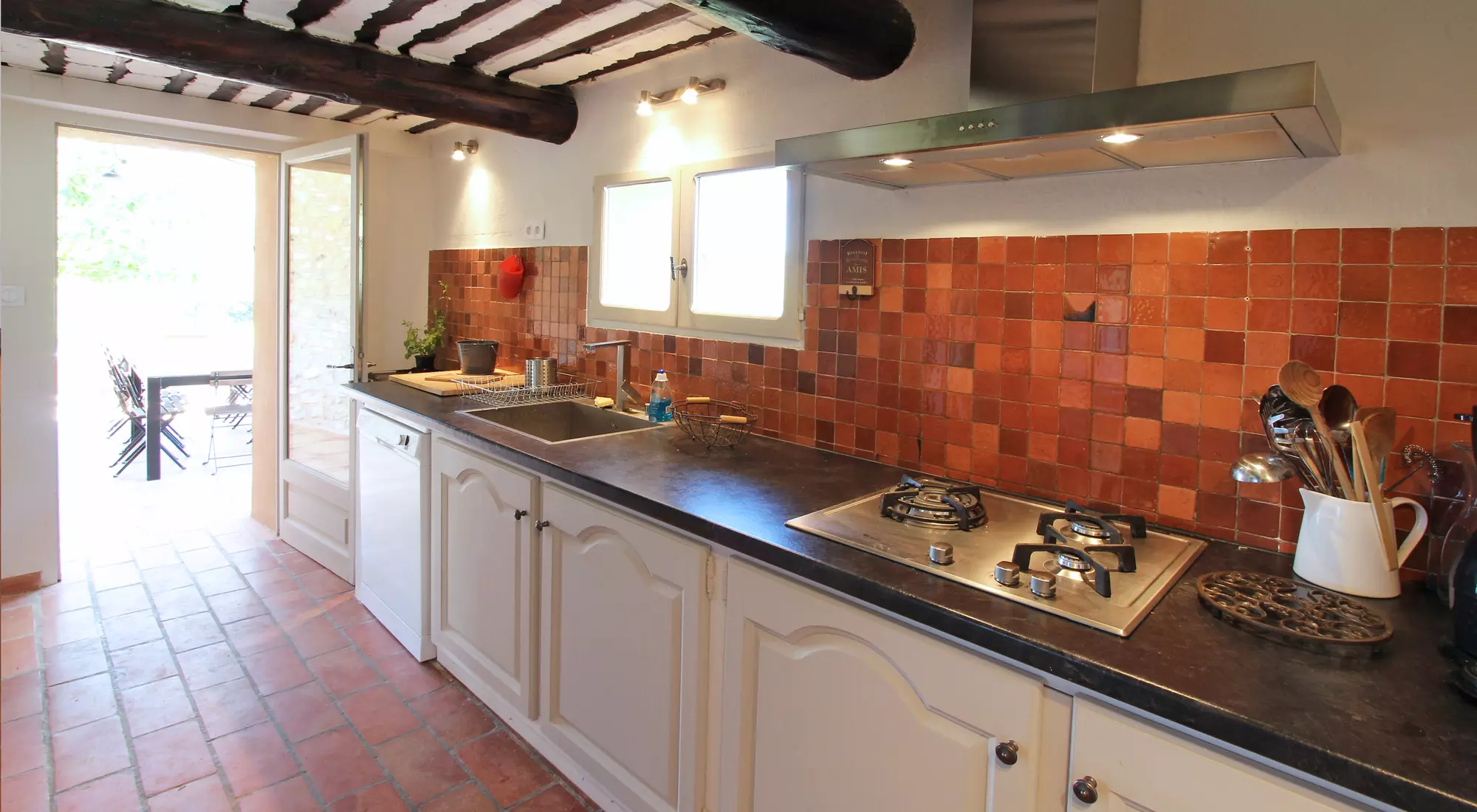 A narrow kitchen opening on the terrace